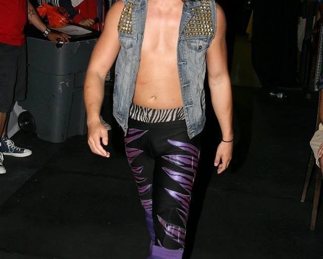 A man in a purple and purple outfit walking down a hallway.