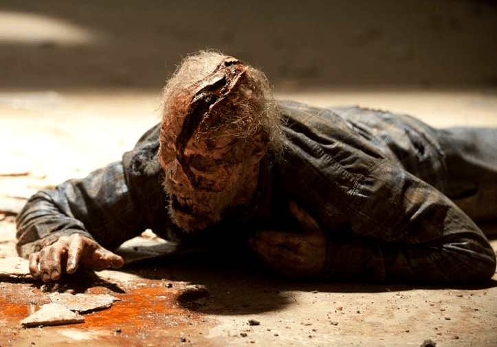 Season 2 of Walking Dead features a man on the ground with blood on his face.