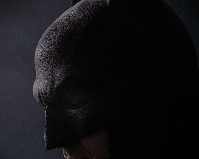 Zack Snyder's rendition of a brooding Batman, in a dark room with his eyes closed.