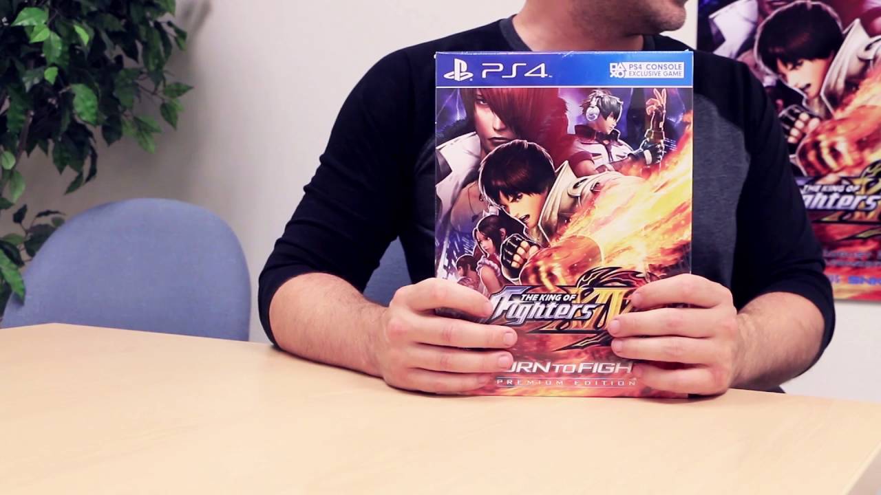 A man holding up a box of King of Fighters XIV.