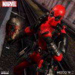 A Deadpool action figure is standing next to a train.