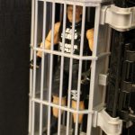 A Mattel figure in a cage.