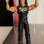 A Mattel toy action figure of a wrestler flexing his muscles.