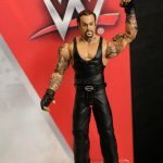 A Mattel WWE action figure with a tattoo on his arm.