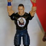 A Mattel wrestler figure with his fists up.