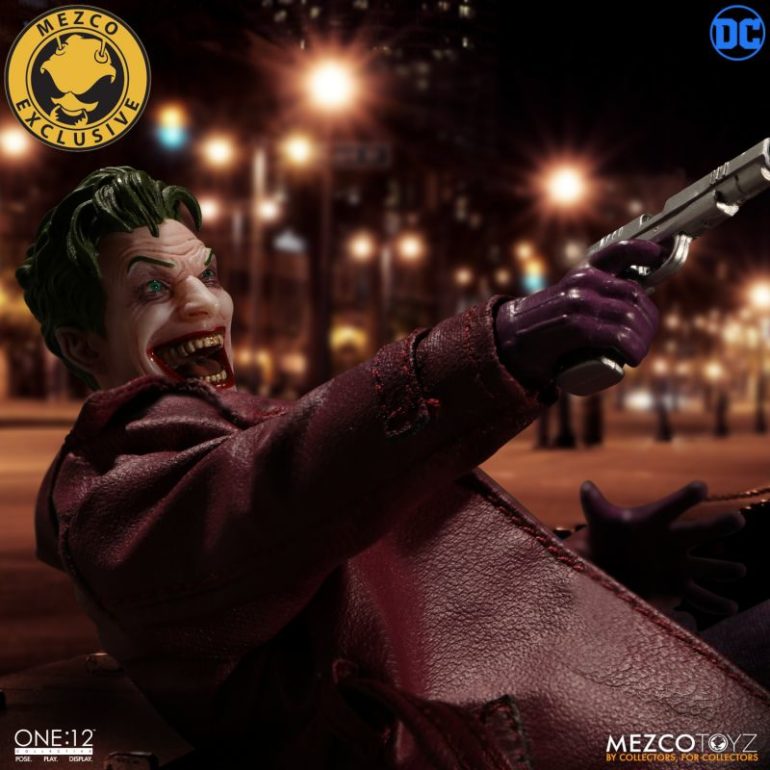 The Joker is holding a gun in his hands.