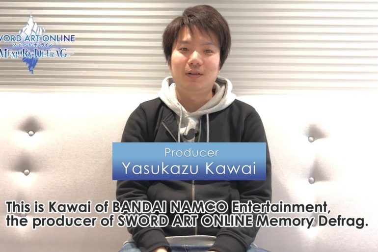 A young man, who is a fan of Sword Art Online, is sitting on a couch as he celebrates playing Memory Defrag.