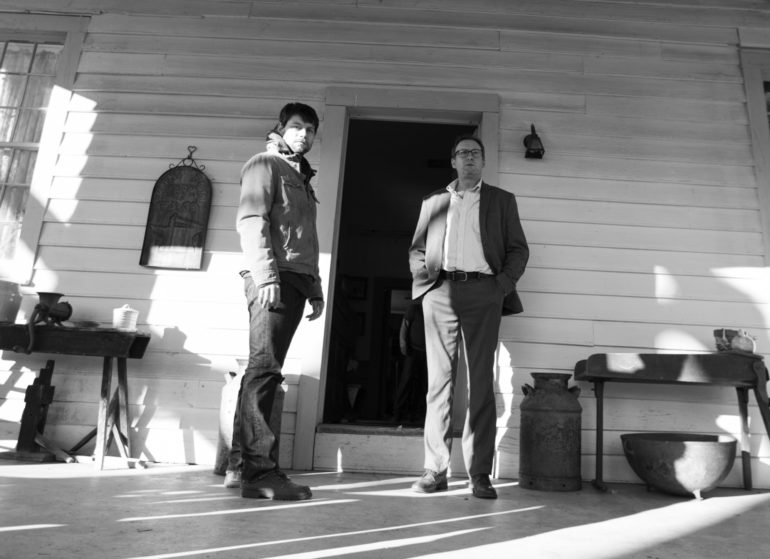 Two men standing in front of a house in Season 2 of Outcast, created by Robert Kirkman.