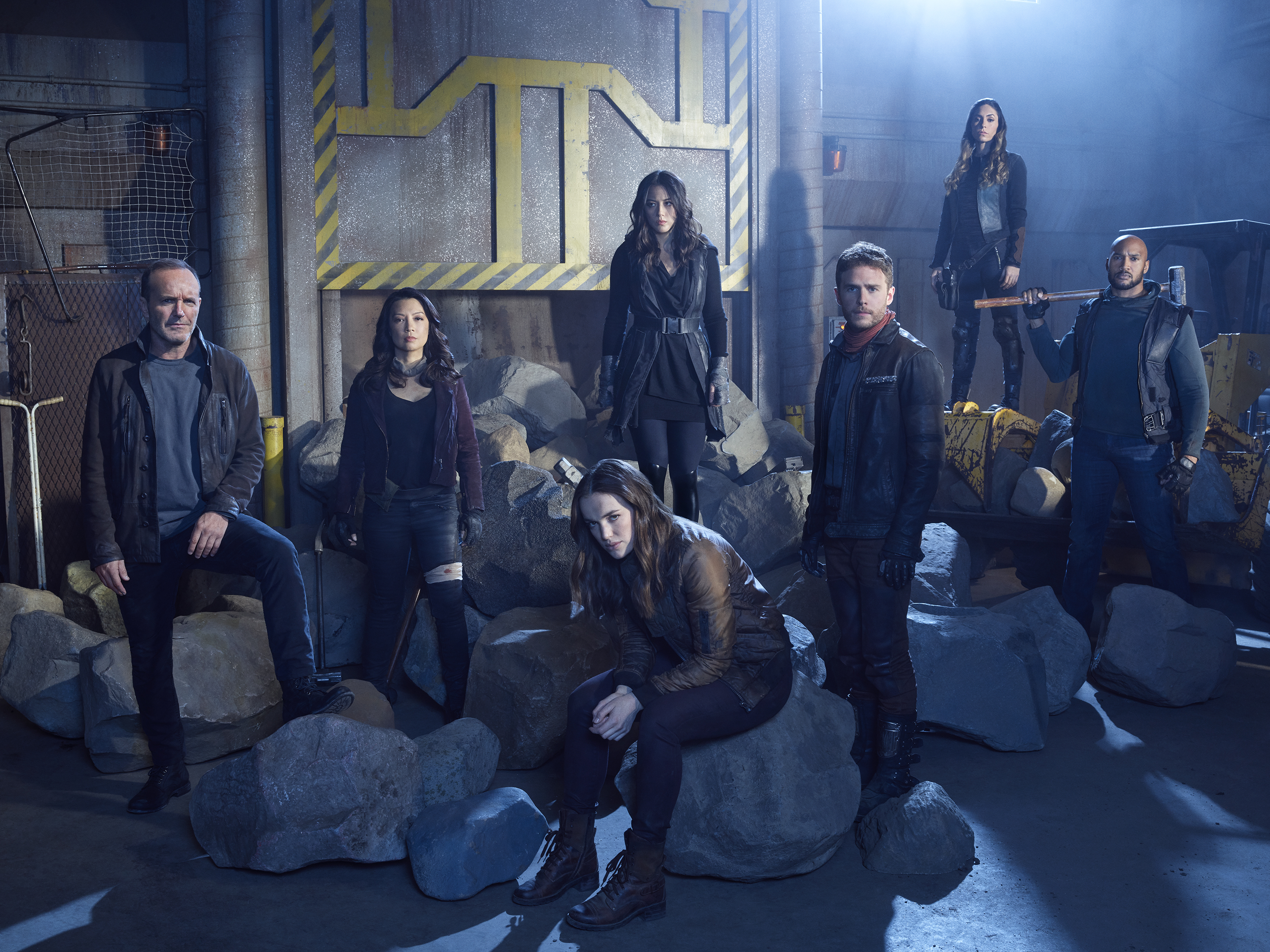 A group of Agents of S.H.I.E.L.D posing in front of rocks.