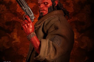 The Hellboy action figure, part of the One:12 Collective series, is holding a gun.