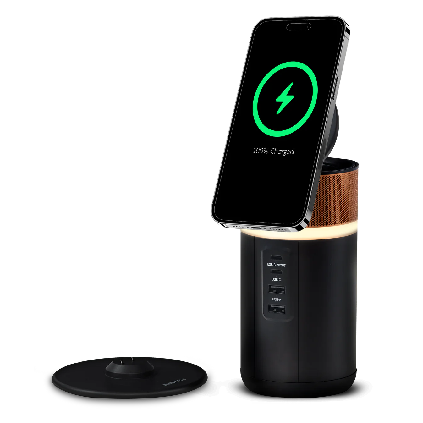 A smartphone is wirelessly charging on a cylindrical charging stand with a glowing LED base, featured in the Holiday Tech Gift Guide. Nearby, a detached circular top with a control knob is visible, offering innovation at its finest.