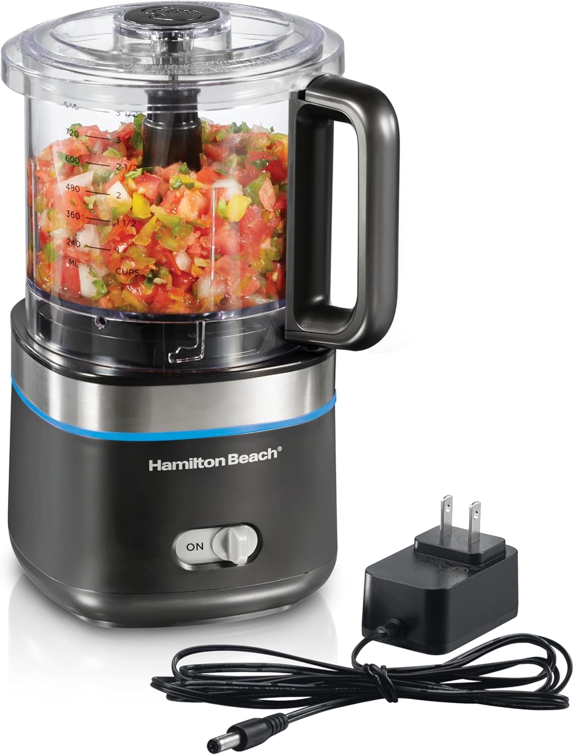 A Hamilton Beach food processor with chopped vegetables inside, accompanied by a power adapter and plug, is a perfect addition to any Holiday Tech Gift Guide.